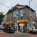 남도집 건물 전경, 붉은 벽돌 3층 건물과 노란색 간판