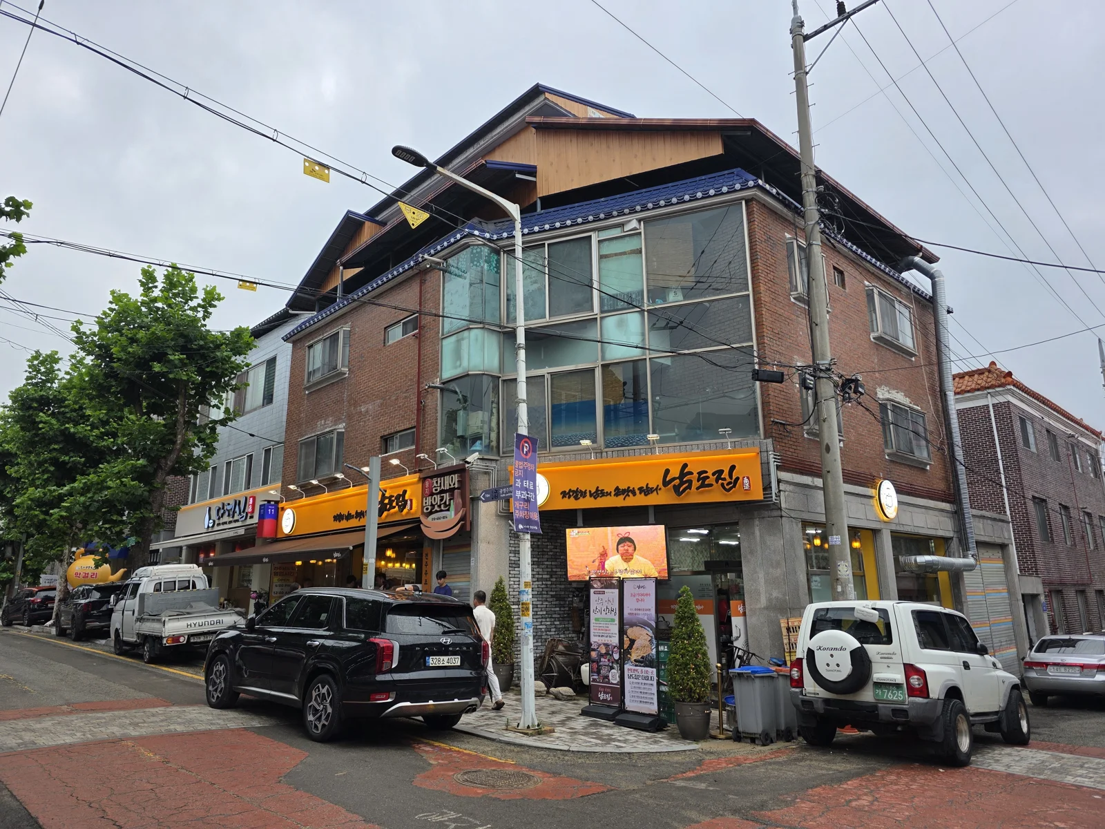 남도집 건물 전경, 붉은 벽돌 3층 건물과 노란색 간판