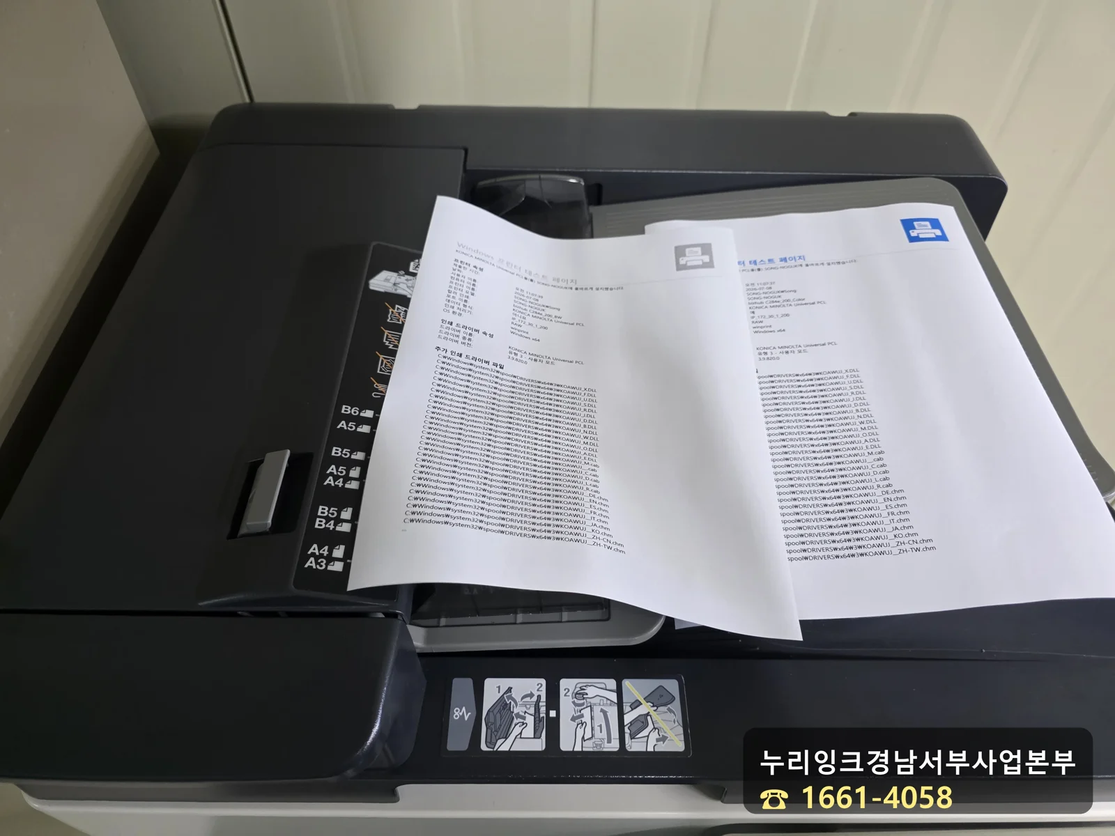 흑백과 컬러 인쇄 테스트 페이지가 출력된 복합기 트레이