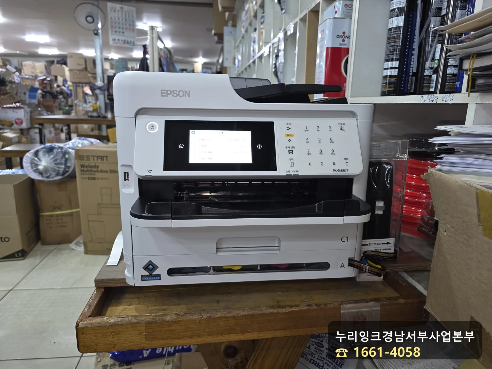 사천 거래처 나무 탁자 위에 새로 설치한 EPSON PX-M887F 프린터와 오른쪽 외장 잉크탱크