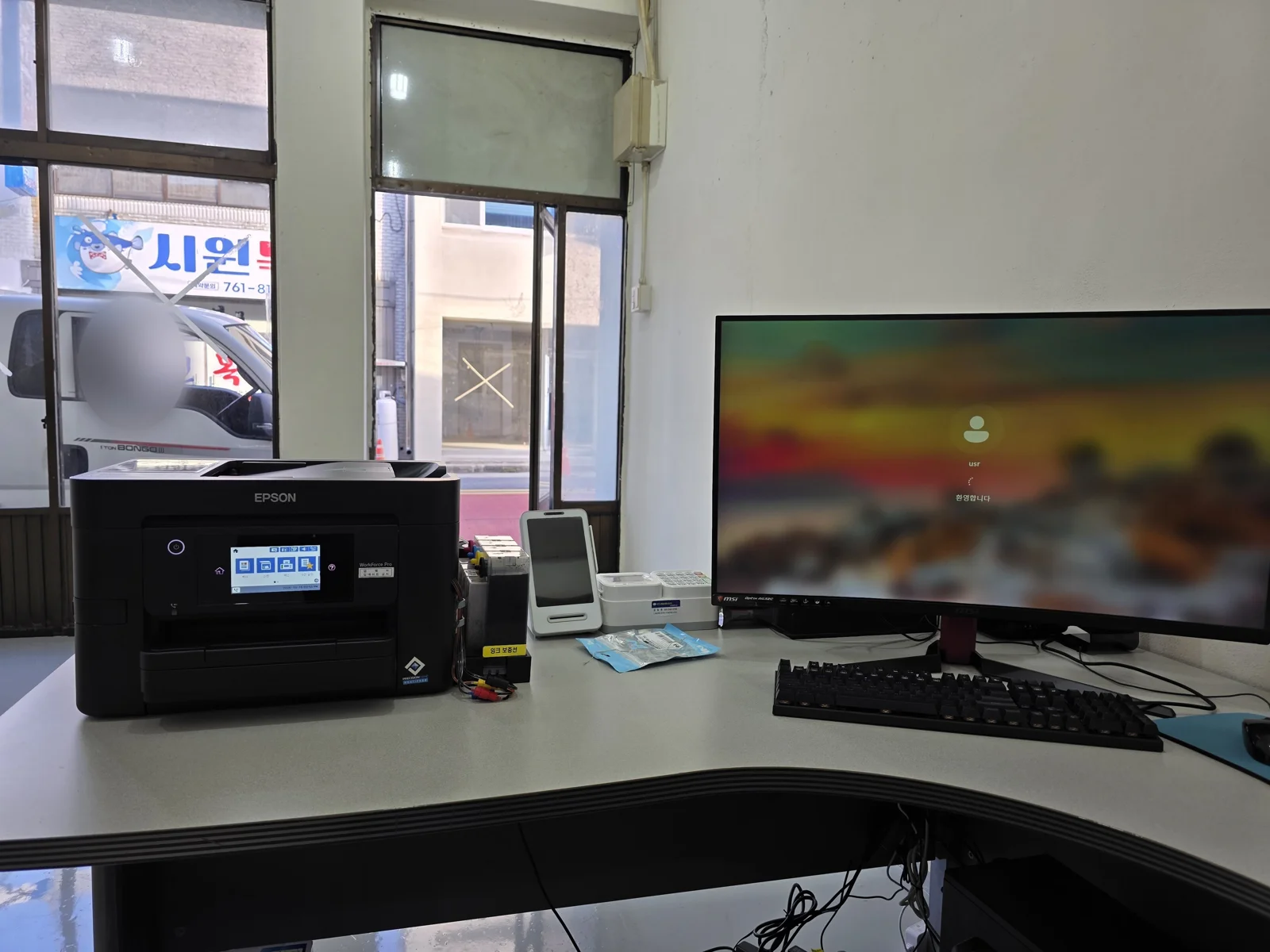 진주 새 사무실 창가 L자형 책상에 설치된 엡손 복합기와 곡면 모니터